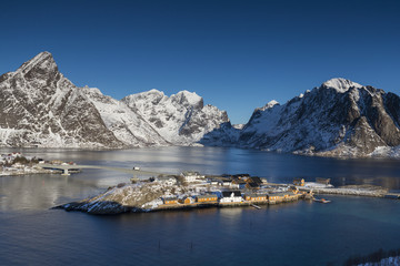 Obraz premium Aerial view on Sakrisoya village with rorbuer, mountains and fjo