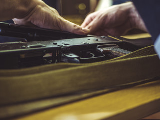 man disassemble rifle close up on the table