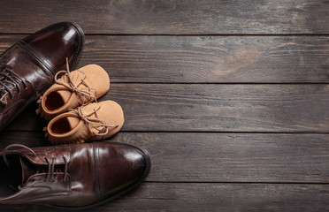 Flat lay composition with big and small shoes on wooden background. Father's day celebration