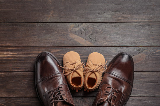 Flat Lay Composition With Big And Small Shoes On Wooden Background. Father's Day Celebration