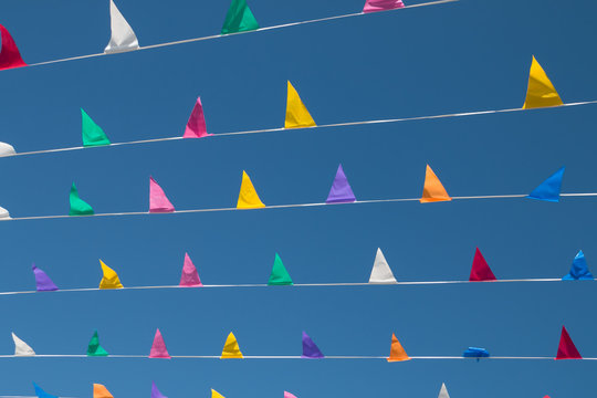 Colorful, triangular bunting on a background of blue sky on a sunny day.