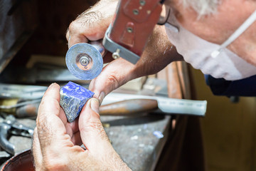 Jeweler engraving diamonds on a ring.