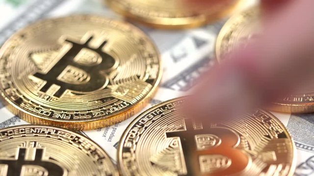 Bitcoins on dollar banknotes background, closeup