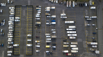Aerial view of a large parking lot for cars, trucks, motorcycles and caravans. The lines of the parking lots are yellow and there are still many free places on the asphalt.