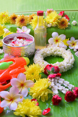 Obraz na płótnie Canvas Thai traditional jasmine garland and Colorful flower in water bowls decorating and scented water, perfume, marly limestone, pipe gun on Banana leaf for Songkran Festival or Thai New Year