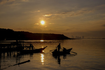 Fisherman using a boat for fishing during sunrise