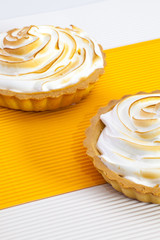 Two lemon tartalets on the white desk