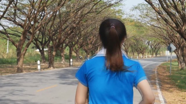 slow motion of fitness woman running in the park