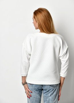 Young beautiful woman posing in new casual white sweater backside rear view