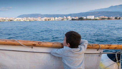Boy looking at seascape and Chania city, Crete, Greece