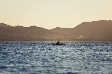 Obraz premium Fisherman in a small wooden boat
