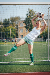 Female athlete does sport exercises in the stadium