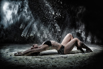Girl dansing with flour on black background © keleny