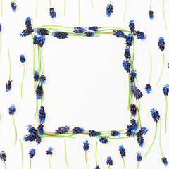 Frame of blue flowers on white background. Flat lay, top view. Spring time composition