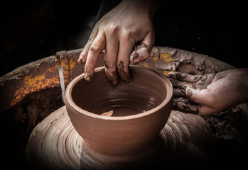 hands of a potter, creating an earthen jar on the circle