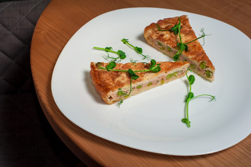 Salmon, peas and cheese pie on white plate