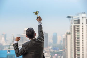 Businessman celebrating with trophy