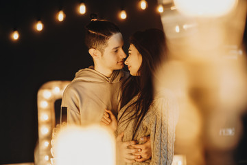 Attractive couple staying face to face and smiling to each other in a decorated room.