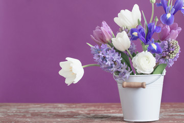 spring flowers in bucket on pink background