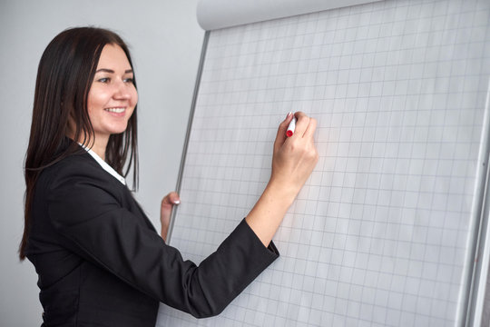 close up of woman with marker writing or drawing something on flip chart
