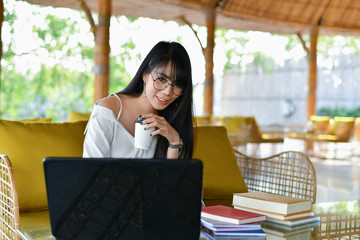 Business Concept.Young Asian businesswoman is working happily.Young businesswoman working in a cafe.Young businesswoman is relaxation in a coffee shop.