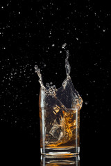 Isolated shot of whiskey with splash on black background