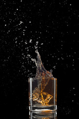 Isolated shot of whiskey with splash on black background