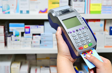 Many medicines on shelf in pharmacy and making purchases, Paying with a credit card and using a terminal
