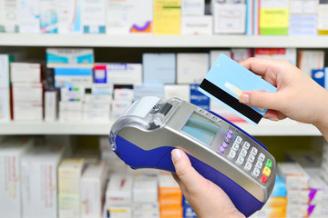 Many medicines on shelf in pharmacy and making purchases, Paying with a credit card and using a terminal