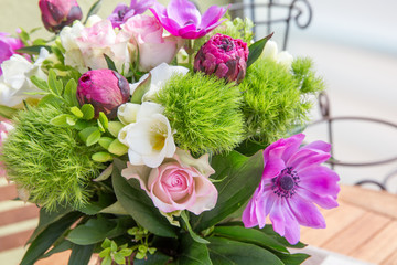 Large beautiful pink bouquet of peonies, roses, anemones in a vase on wooden table. Spring flowers concept.
