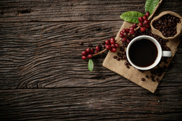 Top view mockup a cup of coffee and coffee beans in the sack on the wooden desk.