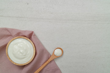 Top view yogurt in bowl on the white stone.Free space for your text.