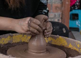 hands of a potter, creating an earthen jar on the circle