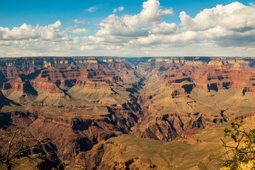 Fototapeta na wymiar Skyline above the grand canyon. Beautiful Grand Canyon shapes under the sunny sky with shadows falling down from the clouds.