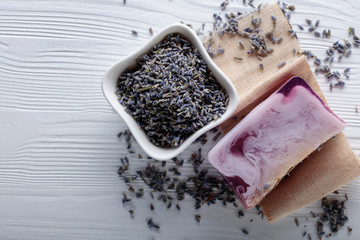 Bar of natural organic soap with lavender on white wooden background.