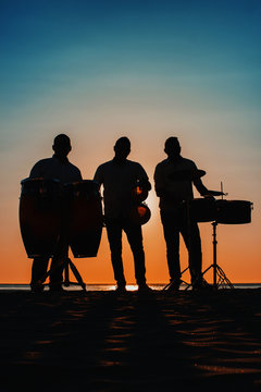 Siluesta de musicos de percusi&oacute;n en el atarecer