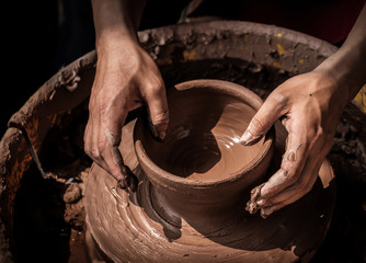 hands of a potter, creating an earthen jar on the circle