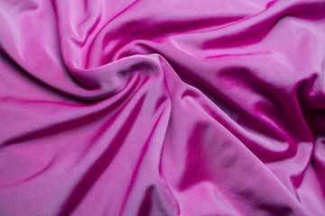 pink fabric with folds in relief. twisted reflective with a texture synthetics effect of silk.