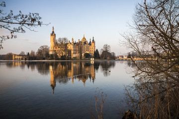 Fototapeta na wymiar Dawn at Schwerin Castle Palace (Schweriner Schloss), reflected in the water of Schweriner See lake. World Heritage Site in Mecklenburg-West Pomerania, Germany