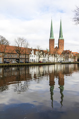 Obraz premium Lubeck, Germany. Views of Lubeck Cathedral (Dom zu Lubeck, Lubecker Dom) reflected in the river Trave. A World Heritage Site since 1987