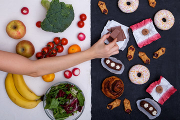 Concept photo of healthy and unhealthy food. Fruits and vegetables vs donuts,sweets and burgers