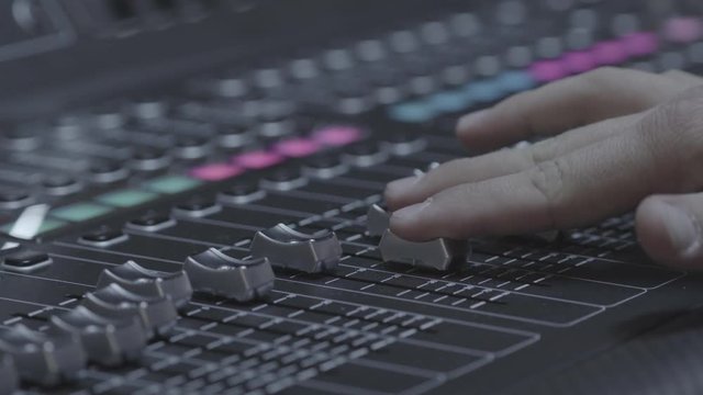 Adjusting the knobs of a sound mixer