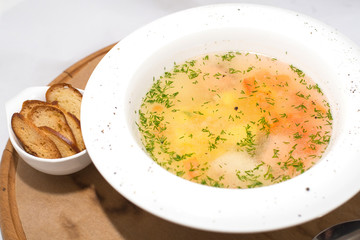 Vegetable soup with dill on a tree on white background