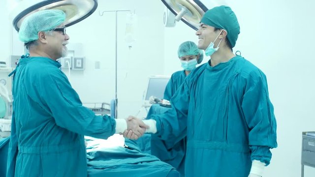 Male doctor shake hand together when finish work. Healthcare and Medical concept. 