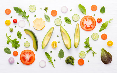 Food pattern with raw ingredients of salad. Various vegetables lettuce leaves, cucumbers, tomatoes, carrots, broccoli, onion and lemon flat lay on white background.