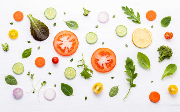 Food pattern with raw ingredients of salad. Various vegetables lettuce leaves, cucumbers, tomatoes, carrots, broccoli, onion and lemon flat lay on white background.