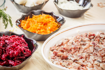 preparing russian traditional salad 'herring under fur coat'