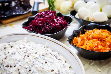 preparing russian traditional salad 'herring under fur coat'