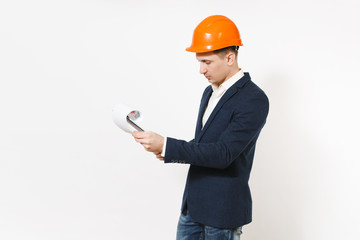 Young handsome businessman in dark suit, protective construction helmet looking on clipboard with papers document isolated on white background. Male worker for advertisement. Business concept.