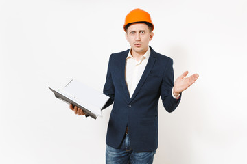 Young concerned businessman in dark suit, protective hardhat holding black folder for papers document and spreading hands isolated on white background. Male worker for advertisement. Business concept.